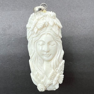 Moose Antler carving of a pendant: Goddess and butterflies, finely carved, silver bail