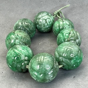 Jadeschnitzerei: Eine handgeschnitzte naturfarbene Jadeitperle, geschnitzt mit Drachen- und Langlebigkeitssymbolen, Jadedrachenperle, naturfarben fei cui