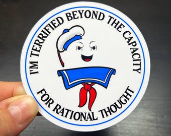 May include: A white circle sticker with a blue and white sailor-themed ghost character. The text around the character reads "I'm Terrified Beyond The Capacity For Rational Thought."