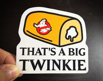 May include: White sticker with a yellow and white cartoon Twinkie with a ghost from the movie Ghostbusters inside. The text "That's a big Twinkie" is below the Twinkie.