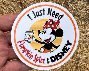 May include: A white round sticker with a red border featuring a cartoon image of Minnie Mouse holding a cup of coffee. The text on the sticker reads "I Just Need Pumpkin Spice & DISNEY".