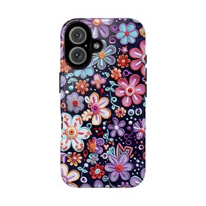 Op de afbeelding: Een telefoonhoesje met een bloemenpatroon. De hoes is versierd met verhoogde bloemen in verschillende kleuren, waaronder roze, paars, oranje en blauw, tegen een donkere achtergrond. Het heeft een glanzende afwerking en een camera-opening.