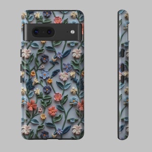 Op de afbeelding: Een telefoonhoesje met een bloemenpatroon. Het hoesje heeft een lichtblauwe achtergrond met 3D-bloemen in tinten roze, blauw en groen.