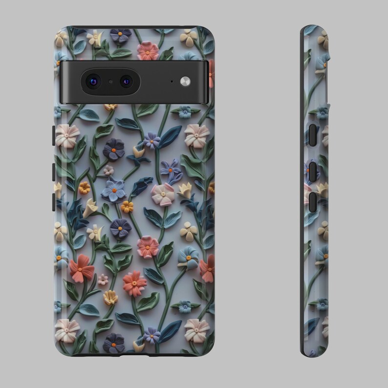 Op de afbeelding: Een telefoonhoesje met een bloemenpatroon. Het hoesje heeft een lichtblauwe achtergrond met 3D-bloemen in tinten roze, blauw en groen.
