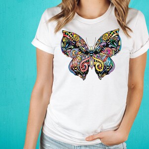 A woman wearing a white t-shirt with a colorful butterfly design on it.