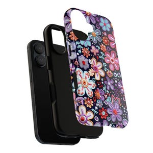 Op de afbeelding: Een zwarte smartphone met een beschermhoes met een kleurrijk bloemenpatroon. De hoes heeft een donkere achtergrond met verschillende bloemen in roze, paars, blauw en oranje. De telefoon is gedeeltelijk zichtbaar.