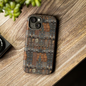 May include: A phone case with a rusty metal design. The case has a dark blue and brown color scheme with a textured surface.