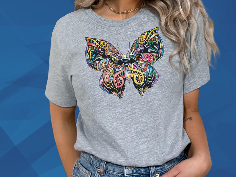 A woman wearing a gray t-shirt with a colorful butterfly design on it.