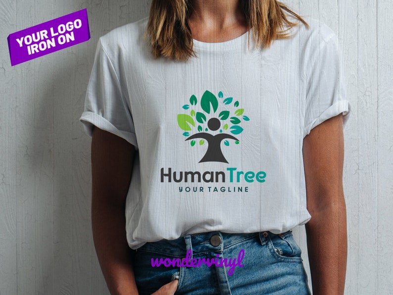 K&ouml;nnte beinhalten: Ein wei&szlig;es T-Shirt mit einem gr&uuml;nen und blauen Baumlogo, das eine menschliche Figur zeigt. Der Logo-Text lautet "HumanTree" und "Your Tagline".