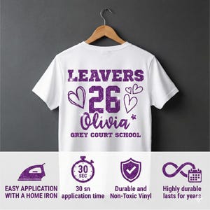 Peut inclure: T-shirt blanc avec texte paillet&eacute; violet &laquo; LEAVERS 26 Olivia &raquo; avec des graphiques de c&oelig;ur et d'&eacute;toile. Le texte &laquo; GREY COURT SCHOOL &raquo; est en dessous du nom. Le bas de l'image montre des ic&ocirc;nes et du texte sur les caract&eacute;ristiques du produit.