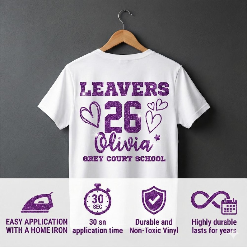 Peut inclure: T-shirt blanc avec texte paillet&eacute; violet &laquo; LEAVERS 26 Olivia &raquo; avec des graphiques de c&oelig;ur et d'&eacute;toile. Le texte &laquo; GREY COURT SCHOOL &raquo; est en dessous du nom. Le bas de l'image montre des ic&ocirc;nes et du texte sur les caract&eacute;ristiques du produit.
