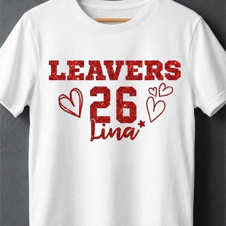 Peut inclure: T-shirt blanc avec un motif rouge scintillant. Le motif comprend le mot "LEAVERS", le chiffre "26", le nom "Lina" et des graphiques de c&oelig;ur. Le t-shirt est en mati&egrave;re douce et a un col rond.