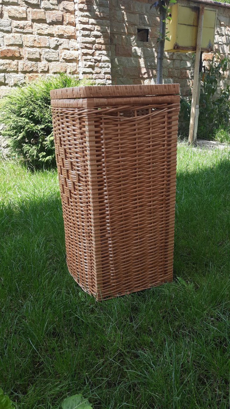 May include: A brown wicker storage basket with a rectangular shape. The basket is made of woven wicker and has a natural finish.