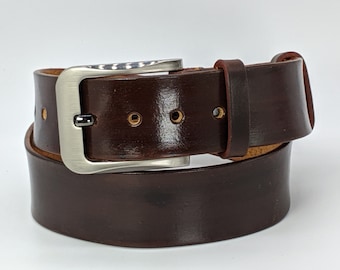 May include: A brown leather belt with a silver buckle. The belt is folded in half and the buckle is visible.