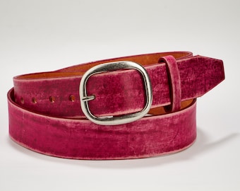 May include: A pink leather belt with a silver oval buckle. The belt is distressed and has a vintage look.