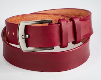 May include: A burgundy leather belt with a silver buckle. The belt is folded in half and the buckle is visible.