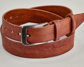 May include: A brown leather belt with a silver-colored buckle. The belt is made of textured leather and has several holes for adjustment. The buckle is rectangular and has a simple, classic design. The belt is a versatile accessory.