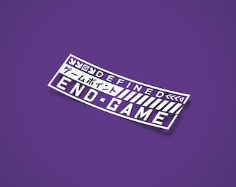Może przedstawiać: Biała naklejka z czarnym tekstem, który brzmi "UNDEFINED END-GAME" z japońskim tekstem, który brzmi "ゲームポイント" nad słowem "END".