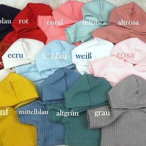 Könnte beinhalten: Eine Auswahl an Baby-Kapuzenpullovern in verschiedenen Farben, darunter Marineblau, Rot, Koralle und Mint. Jedes Oberteil besteht aus einem strukturierten Stoff und hat eine Kapuze. Das Bild zeigt die Oberteile in einer Nahaufnahme und zeigt die Farbpalette.