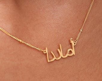 May include: A delicate gold-colored necklace with the name "Lula" in cursive script. The necklace features a fine chain with small, evenly spaced beads. The pendant is in a stylish, elegant font.