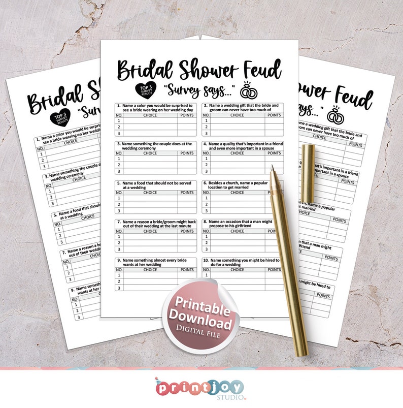 Puede incluir: Hojas de juego imprimibles de Bridal Shower Feud con preguntas para completar. Las hojas tienen un dise&ntilde;o en blanco y negro con el texto "Bridal Shower Feud" y "Survey says..." impreso en ellas. Un bol&iacute;grafo dorado descansa sobre las hojas.