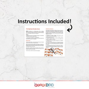 May include: A printed sheet titled Friendsgiving Charades Game with instructions, acting tips, and a set of small orange-bordered cards featuring text. A pair of black scissors rests on top of the cards, and a curved arrow points to the text.