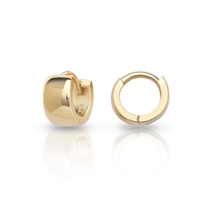 May include: Two gold hoop earrings. One earring is a rounded rectangle shape, and the other is a simple circle. Both earrings are gold and have a shiny finish. The earrings are displayed on a white surface.