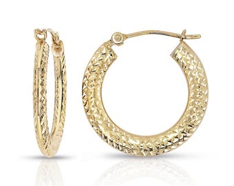 May include: A pair of gold-colored hoop earrings. The earrings have a textured, diamond-like pattern across their surface. The hoops are shown against a white background, with a slight reflection visible below.