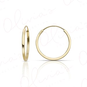 May include: A pair of gold hoop earrings. The earrings are 14k gold and have a simple, classic design.