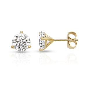 May include: A pair of gold stud earrings with a round, clear gemstone in the center.