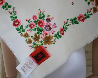 Pode incluir: Lenço floral branco com borda desfiada. O lenço apresenta um padrão floral com flores vermelhas, rosa, roxas e marrons e folhas verdes. Uma etiqueta vermelha com texto está anexada.