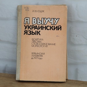 May include: A light tan softcover book with black Cyrillic text on the front cover. The title reads "Я ВЫУЧУ УКРАИНСКИЙ ЯЗЫК" followed by "ФОНЕТИКА ЛЕКСИКА СЛОВООБРАЗОВАНИЕ МОРФОЛОГИЯ" and "УКРАИНСКАЯ ЛИТЕРАТУРА до 1917 года". The author is listed as И.Ф ЮЩУК.