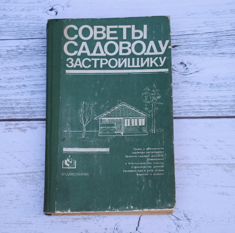 May include: A green book titled "Советы Садоводу Застройщику" with a black and white illustration of a house and trees. The book is published by "Будівельник".