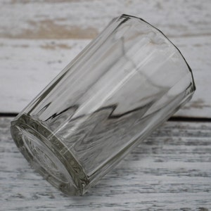 Puede incluir: Un vaso de vidrio transparente para beber con un diseño texturizado y facetado. El vaso está vacío y parece estar hecho de vidrio grueso.