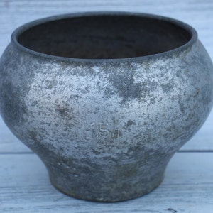 May include: A silver cast iron pot with a worn surface and the number "15" stamped on the side.