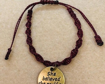Adjustable macrame burgundy bracelet with brass charm “ she believed she could so she did” . Fits most wrists.