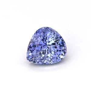 May include: A pear-shaped gemstone with a brilliant cut, displaying shades of blue and purple. The facets catch the light, creating a sparkling effect. The gem is set against a white background.