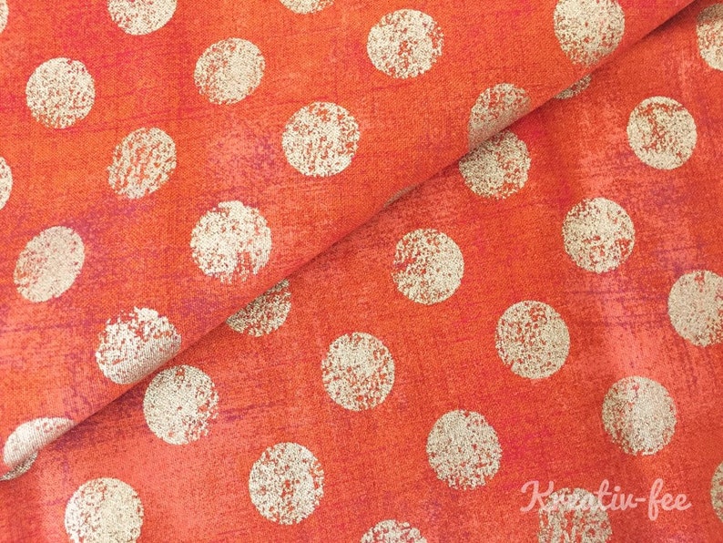 Peut inclure: Gros plan sur un tissu avec un motif r&eacute;p&eacute;t&eacute; de grands pois blanc cass&eacute; sur un fond orange vif. Le tissu a un aspect textur&eacute; avec de subtiles variations de couleur, cr&eacute;ant une surface visuellement int&eacute;ressante.