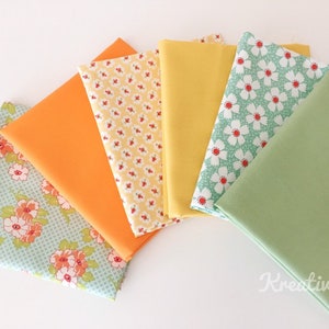 Könnte beinhalten: Eine Sammlung von Stoffquadraten in verschiedenen Farben und Mustern. Die Stoffe umfassen die Farben Orange, Gelb und Grün sowie Stoffe mit floralen Mustern in Orange, Rot und Weiß auf hellblauem und gelbem Hintergrund. Die Stoffe sind fächerförmig angeordnet.