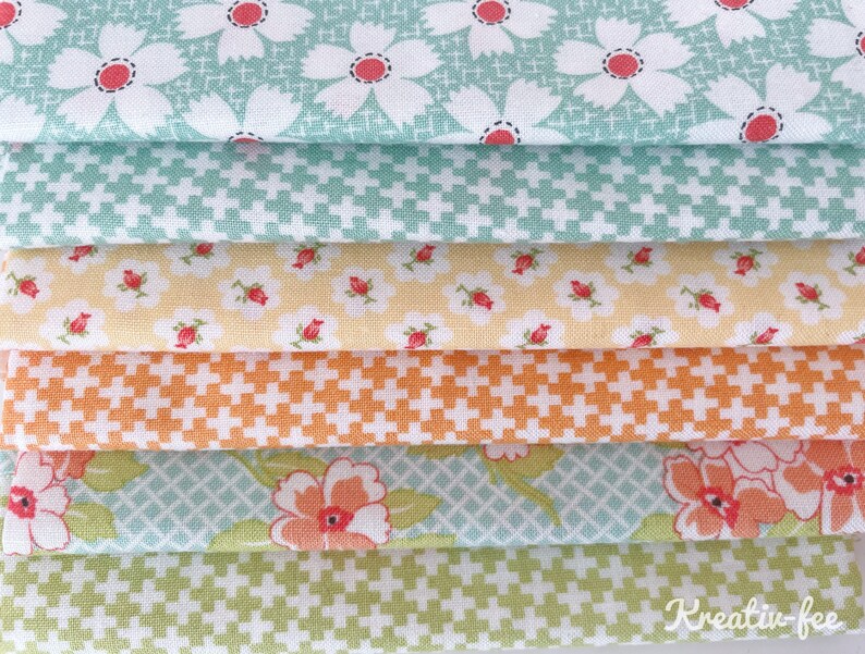 K&ouml;nnte beinhalten: Ein Stapel bunter Stoffmuster mit floralen und geometrischen Mustern. Die Stoffe zeigen wei&szlig;e G&auml;nsebl&uuml;mchen mit roten Zentren, Pluszeichen und andere florale Designs in Gr&uuml;n-, Gelb- und Oranget&ouml;nen. Der Text "Kreativ-fee" ist sichtbar.