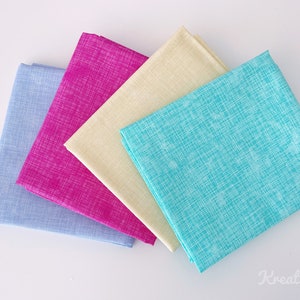 Könnte beinhalten: Vier gefaltete Stoffquadrate in Blau-, Rosa-, Creme- und Türkistönen. Jedes Quadrat hat ein strukturiertes Kreuzschraffurmuster in Weiß. Die Stoffe sind diagonal angeordnet und zeigen ihre Farben und Texturen. Das Bild ist gut beleuchtet und hebt die Details des Stoffes hervor.