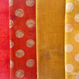 Peut inclure: Gros plan sur quatre &eacute;chantillons de tissu dans les tons de rouge, orange et jaune. Le premier &eacute;chantillon est rouge avec un motif d'&eacute;clat d'&eacute;toile. Le second est orange avec de gros pois blancs. Le troisi&egrave;me est jaune moutarde uni. Le quatri&egrave;me est jaune avec des pois blancs.