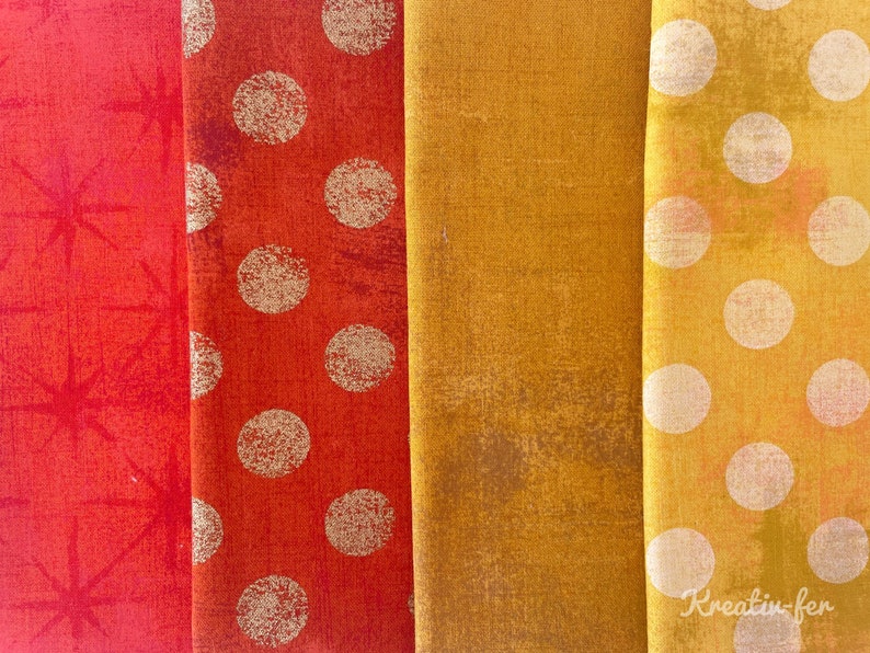 Peut inclure: Gros plan sur quatre &eacute;chantillons de tissu dans les tons de rouge, orange et jaune. Le premier &eacute;chantillon est rouge avec un motif d'&eacute;clat d'&eacute;toile. Le second est orange avec de gros pois blancs. Le troisi&egrave;me est jaune moutarde uni. Le quatri&egrave;me est jaune avec des pois blancs.