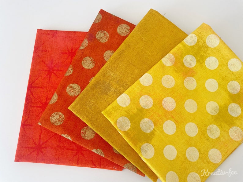 Peut inclure: Quatre serviettes en tissu pli&eacute;es dans des tons de rouge, orange et jaune. Les serviettes pr&eacute;sentent divers motifs, notamment des &eacute;clats d'&eacute;toiles et des pois dor&eacute;s. Ces serviettes sont probablement pour la d&eacute;coration int&eacute;rieure ou la restauration.