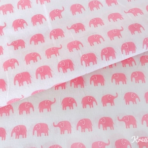 May include: White fabric with a repeating pattern of pink elephants. The elephants are stylized and evenly spaced across the fabric. The fabric is folded, showing the pattern on both sides.