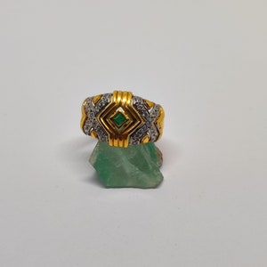 Anel com esmeralda e zircões em ouro 18k