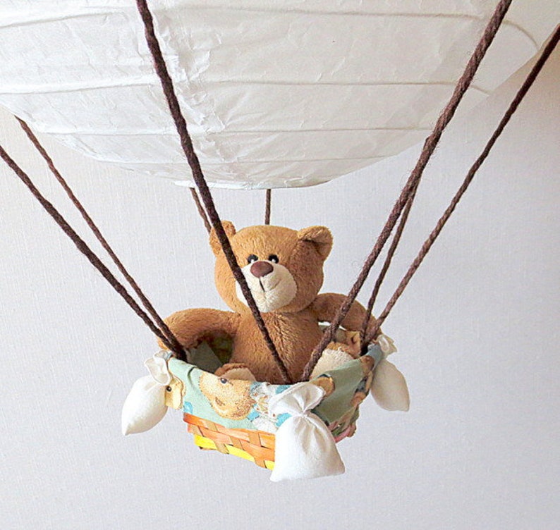 teddy bear hanging from balloons