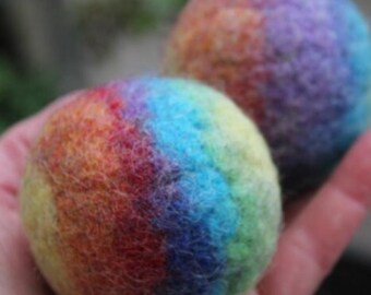Two rainbow-colored balls made of felted wool, colored red, blue, green, yellow