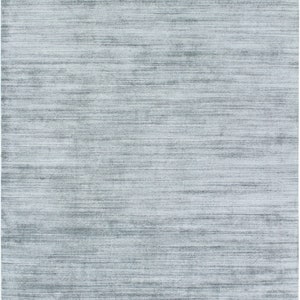 Puede incluir: Una alfombra azul claro con un diseño tejido sutil y texturizado.