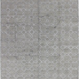 Puede incluir: Una alfombra gris con un patrón geométrico blanco de círculos entrelazados.